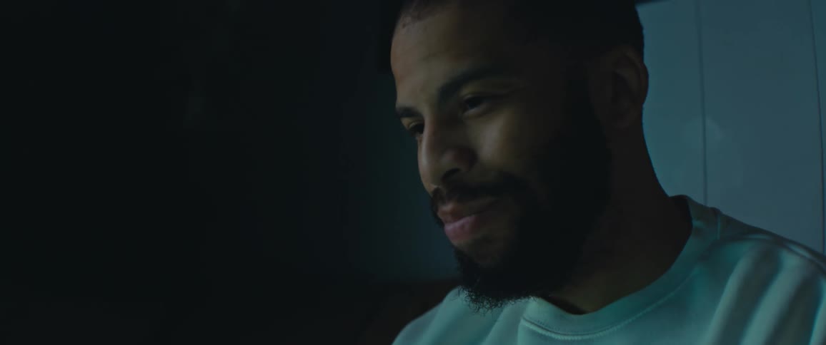 A man smiles while shaking his head