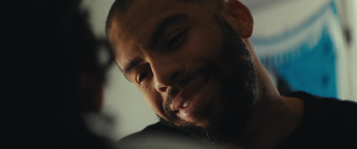 Man smiles while talking to a female indoors