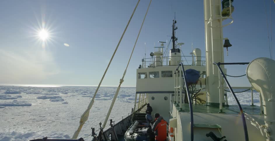 A large boat navigates through icy water