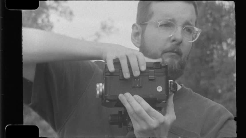 Man setting up a camera on a tripod