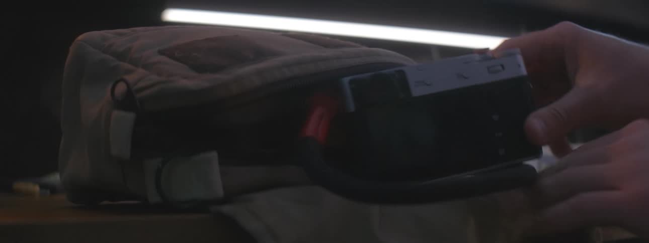 A person removes a camera from their bag