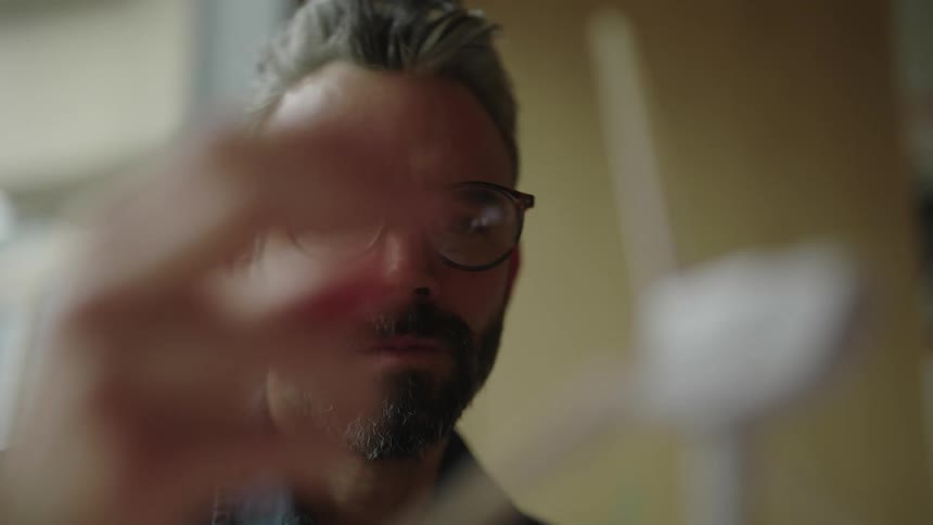 Concentrated man interacting with a wind powered toy