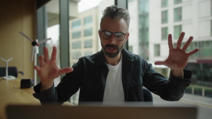 Man is talking to someone while sitting in an office
