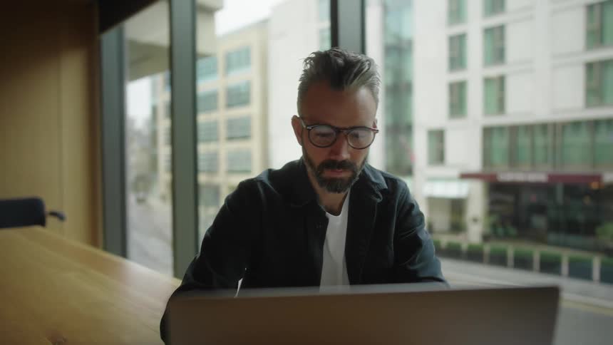 A man is typing on his laptop in the conference room