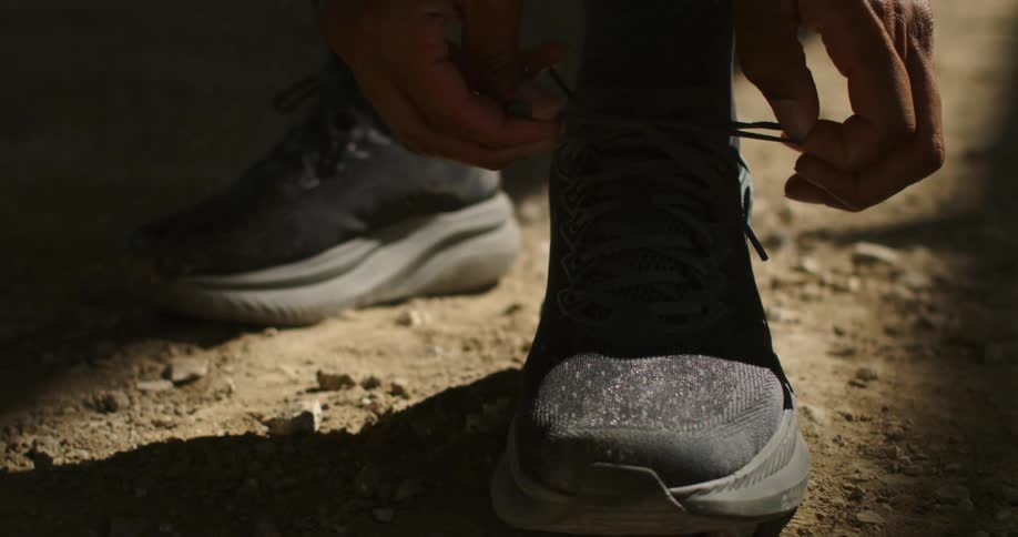 A man is tying his sneakers