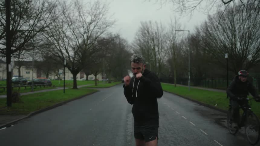 Man running on the street and throwing boxing punches