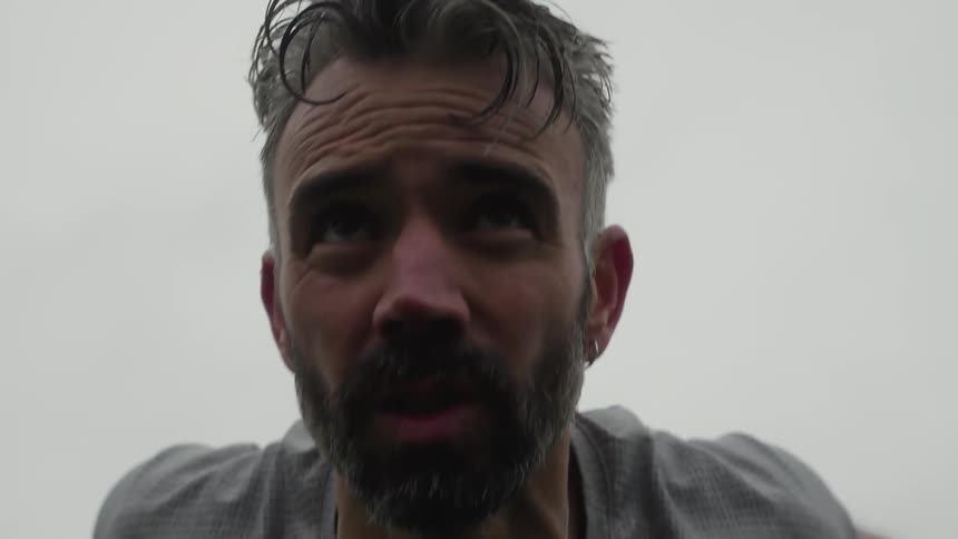 Sweaty panting man in gray tshirt does pushups