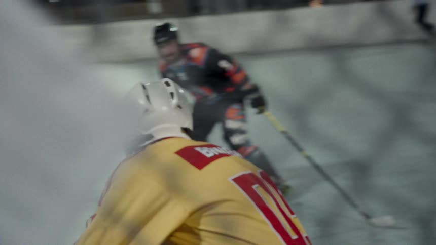 People playing hockey on a rink at night