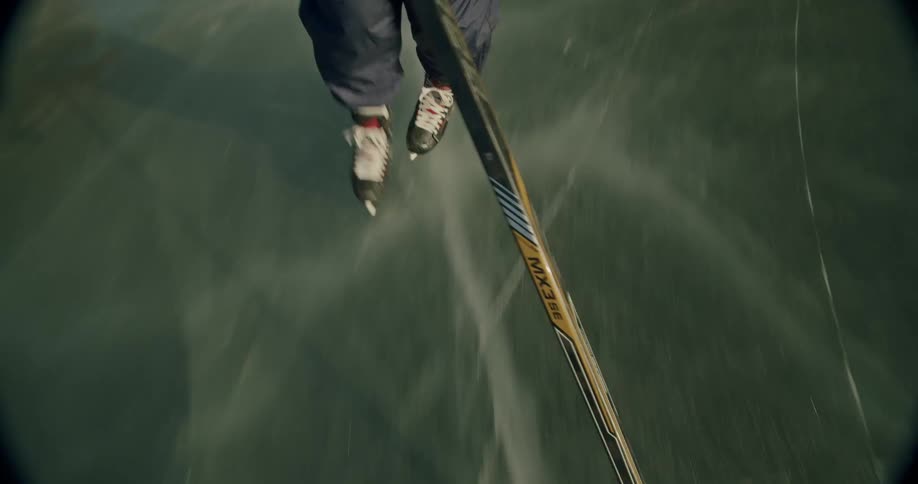 A person is ice skating on a frozen surface viewed from a topdown perspective