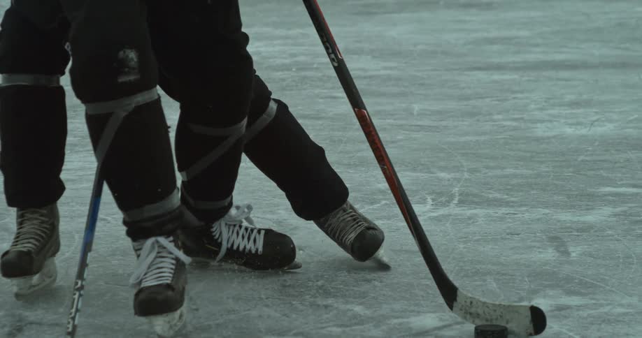 Hockey players compete for control of the puck on the ice during an intense game
