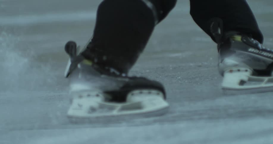 Hockey player skates on ice while holding a stick