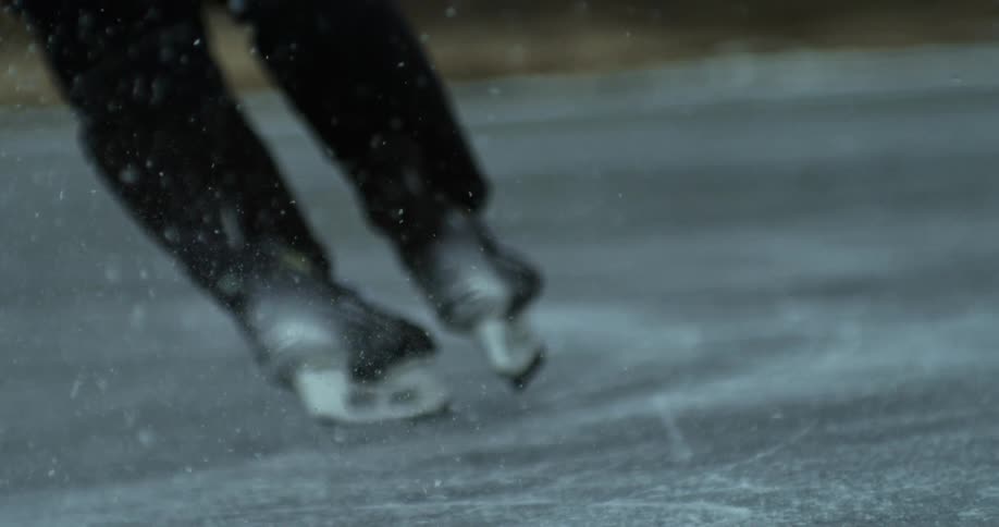 Hockey player skates across an outdoor ice rink