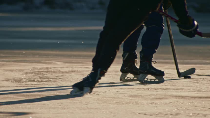 Two people playing a game of ice hockey