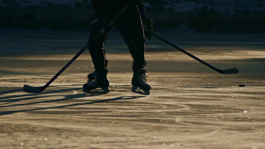 Person with a stick playing hockey on an ice rink