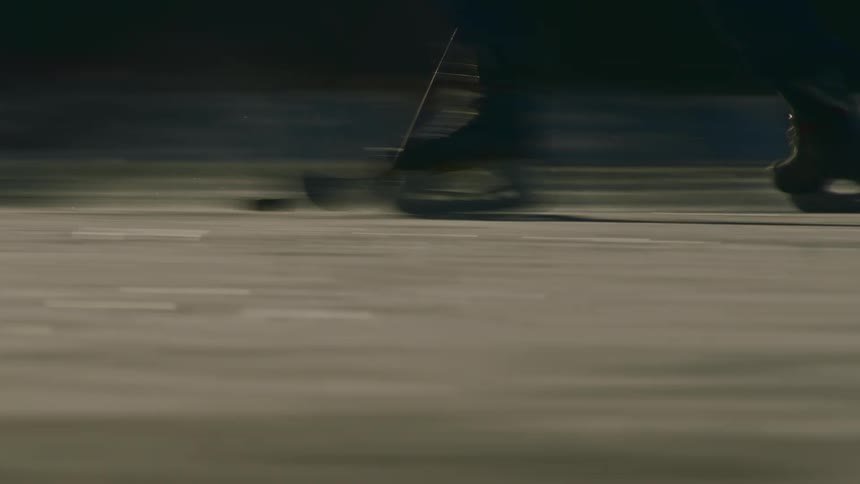 Hockey players feet are shown skating quickly across the ice