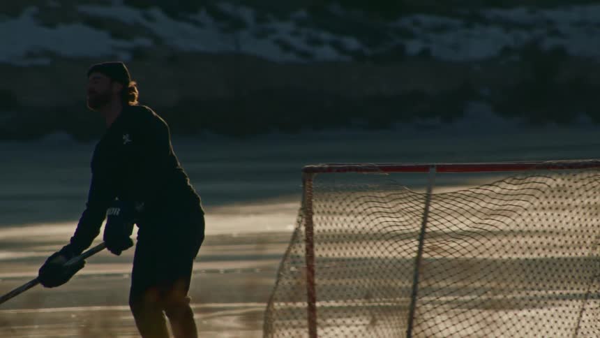 Two men outdoors playing hockey