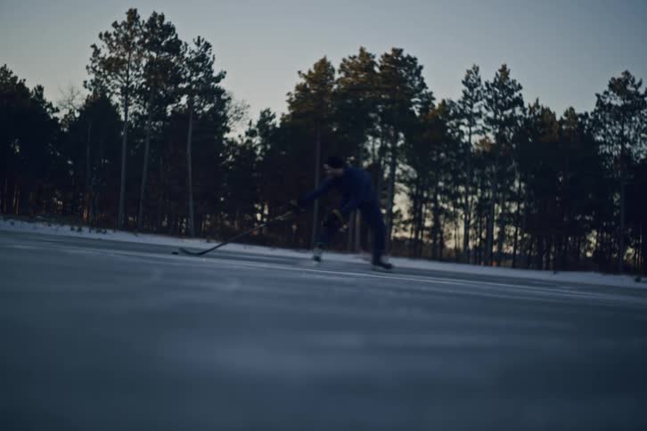 Two men in the snow playing hockey