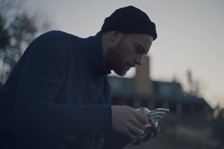 Man in cap outdoors checking his ice shoe