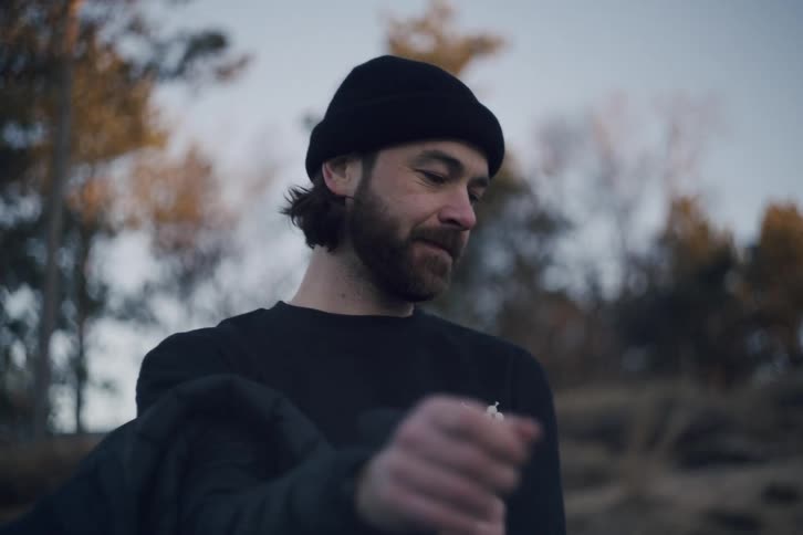 Man in cap taking off his jacket