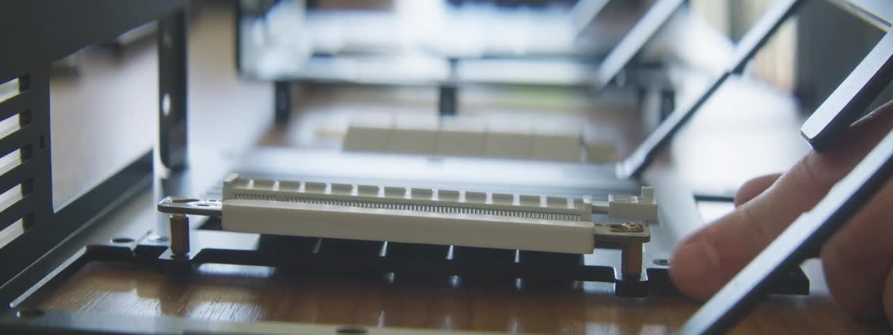 Hand with a tool screwing a computer component