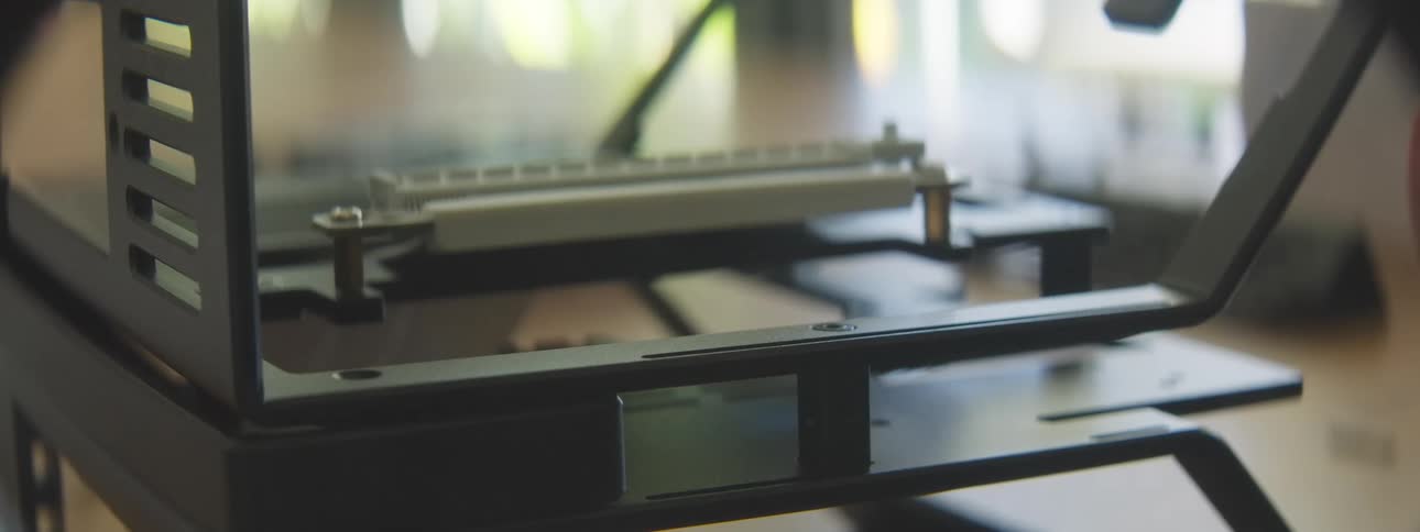 A closeup shot shows a hand adjusting a small screw on a computer metal frame