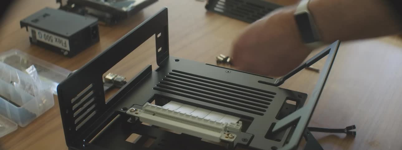 Hands assembling a computer case securing components with screws