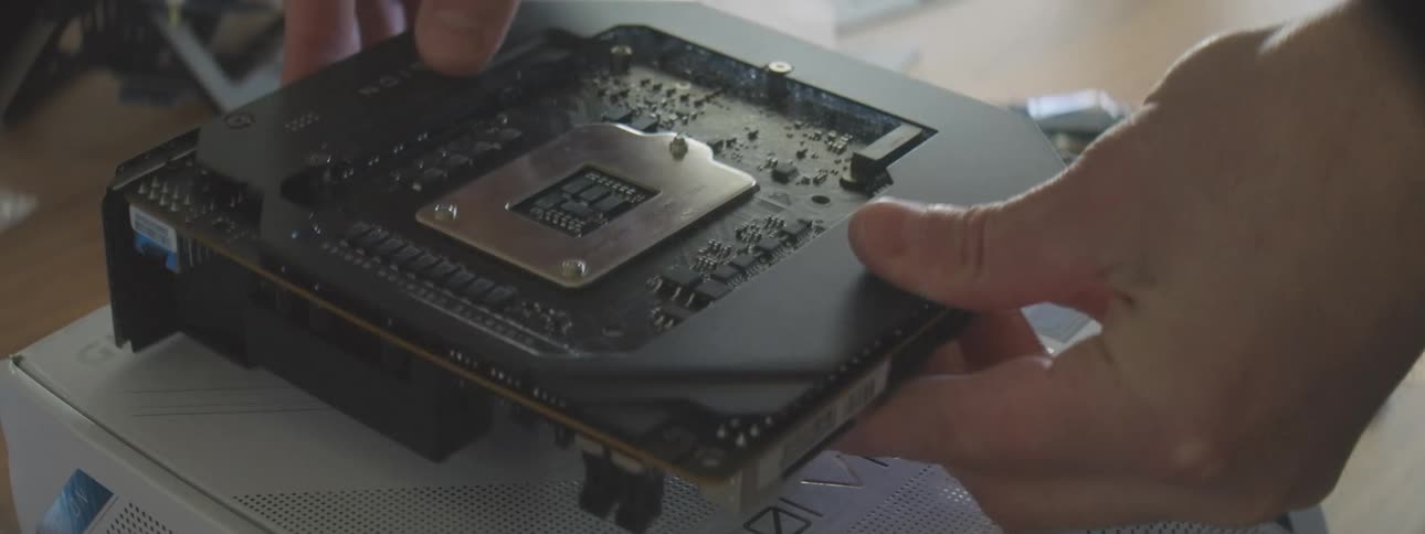 Person handles a motherboard while assembling a computer