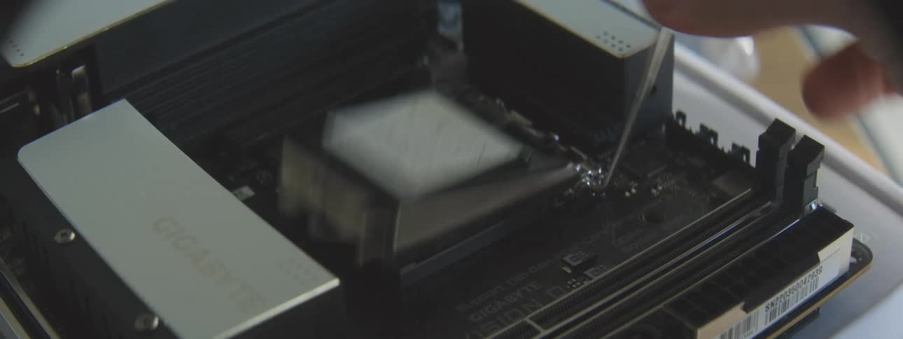 Person uninstalls a component on a motherboard while assembling a computer