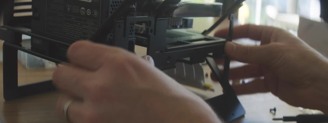 Person assembles a computer adjusting the structure and internal components