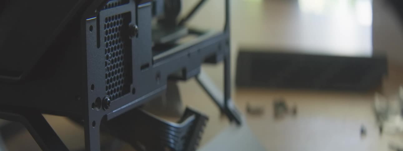 Person tightens a screw on the back of a computer case during assembly