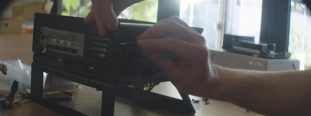 Person installs or adjusts a component in an open computer case