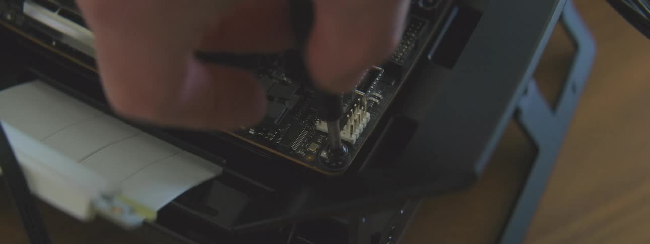 A person puts a screw into the motherboard