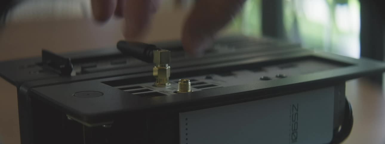 A person screws in antennas into an internet router