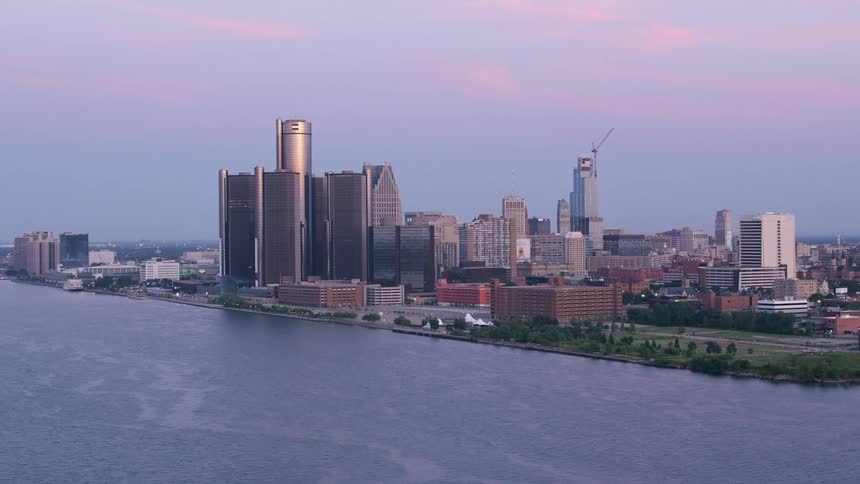 An aerial shot shows the detroit skyline at dusk featuring the renaissance center along the detroit river