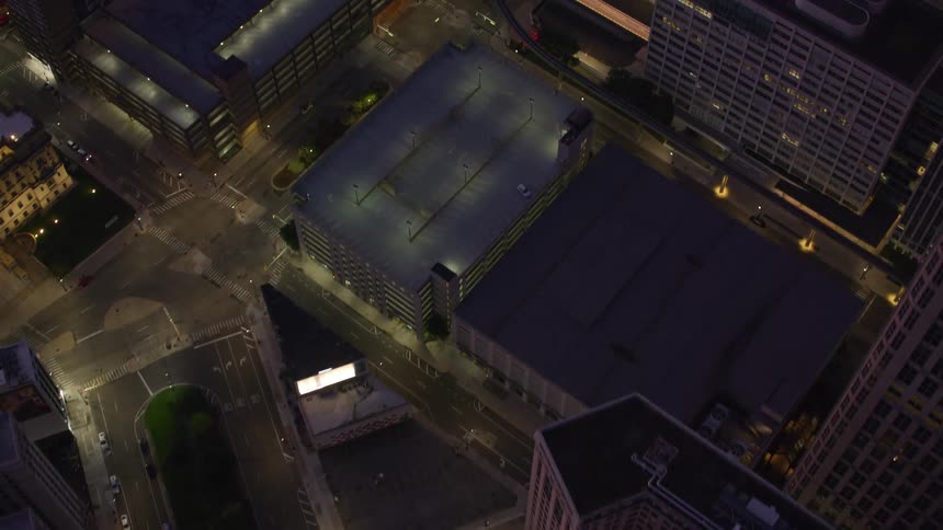 Aerial view of a city at night with illuminated skyscrapers and busy streets