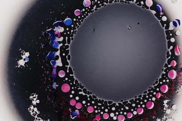 Gray fluid drops and shrinks into another dark fluid