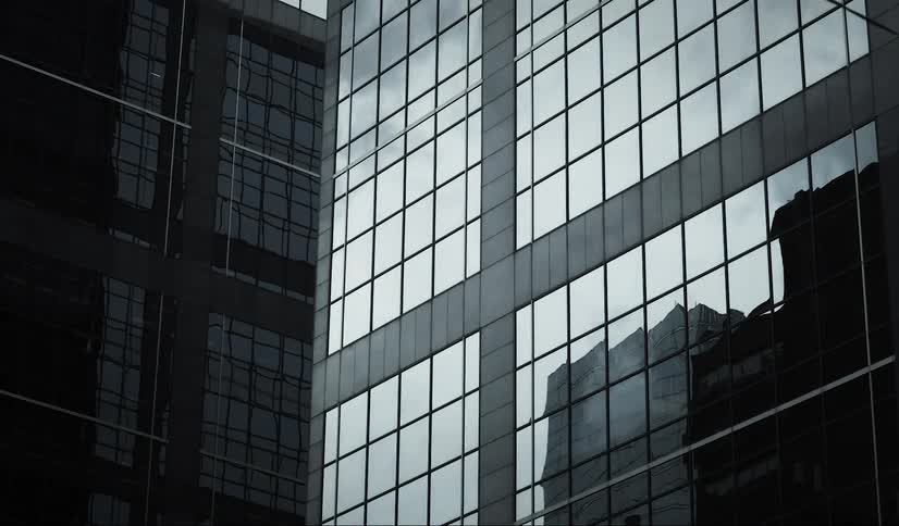 Reflective downtown skyscrapers reflect the passing clouds