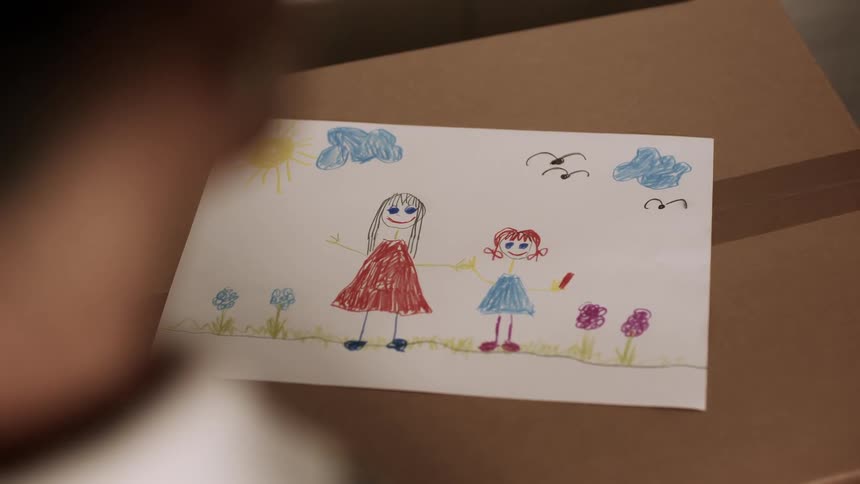 Looking at a childs drawing of a mom and daughter outdoors in a flower field