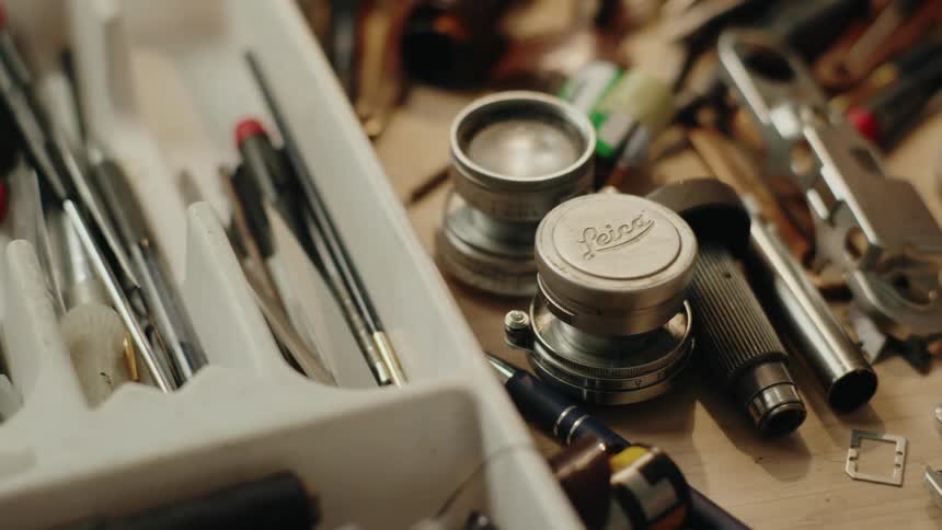 A persons hand using a metal tool to straighten a round object
