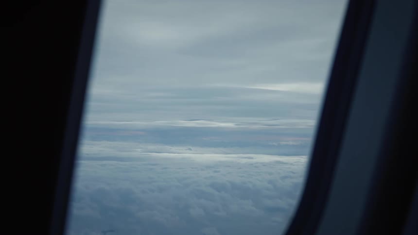 Landscape of sky with clouds seen through the window of an airplane in flight