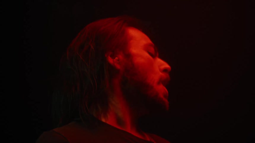 Bearded man playing guitar at a performance