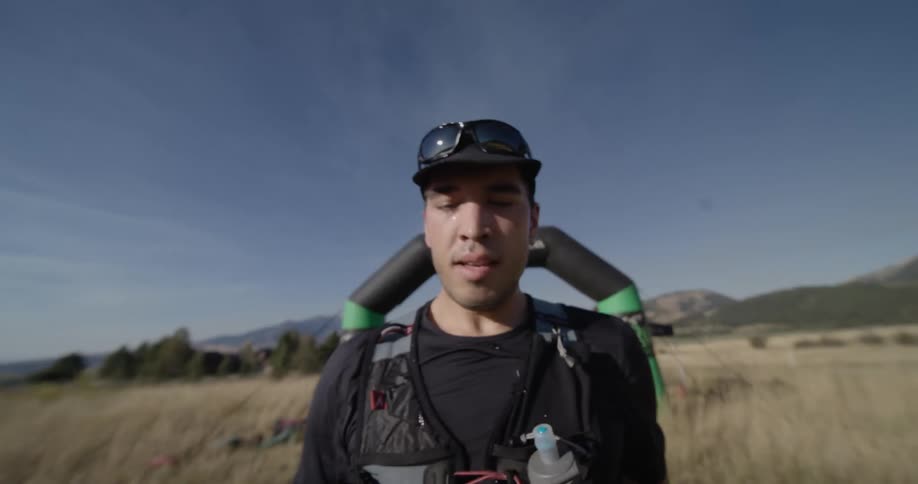 Runner splashes water on his face as he passes through an inflatable arch during an outdoor competition