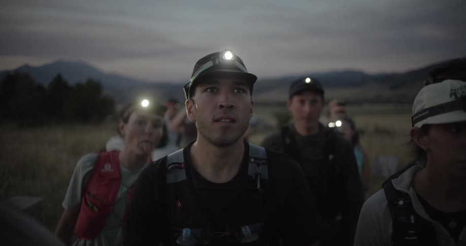 People stand in a group while all are reading head lights