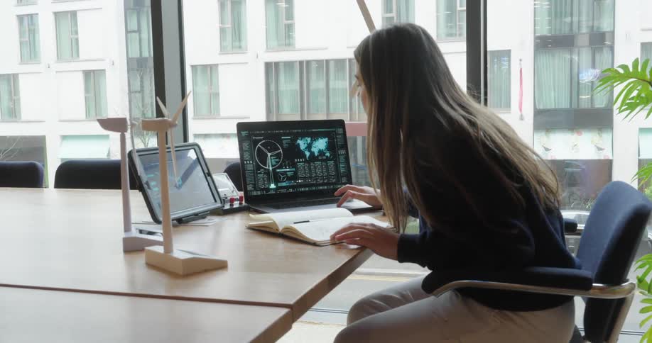 A teenager is using a laptop and a tablet in the office