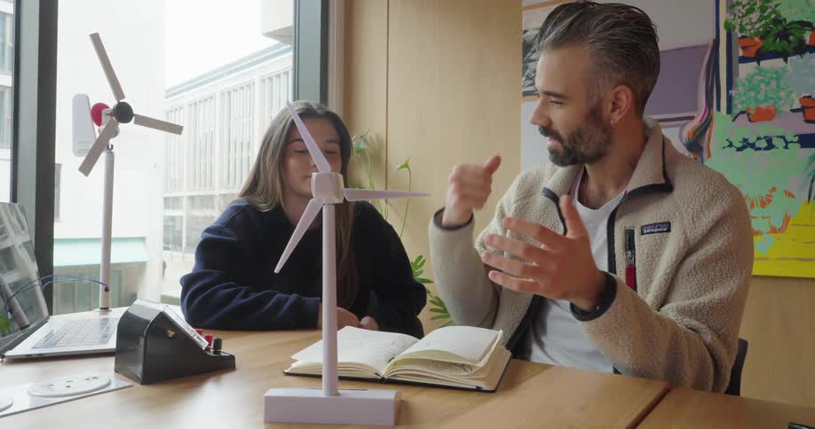Woman and a man sitting at a table talking about wind energy models
