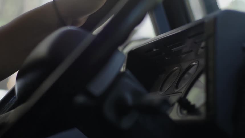 Driver rotating a car steering wheel