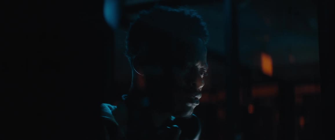 Portrait of a scared man while standing in a dark indoor environment