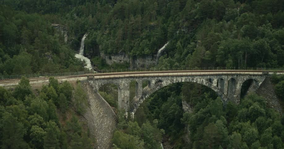 Aerial view of a bridge connecting a mountain valley with waterfalls