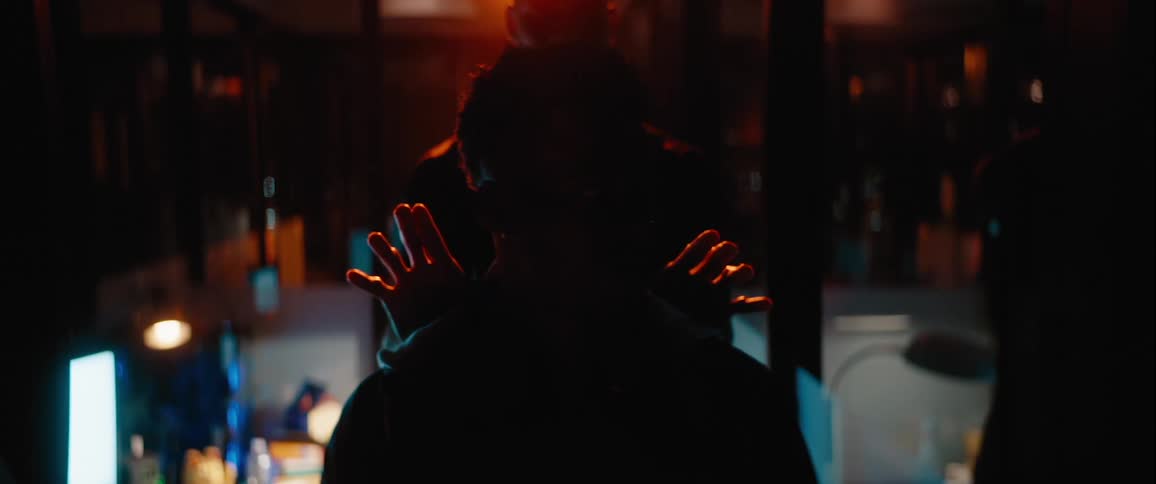 A person slowly puts his hands on a mans shoulders from behind