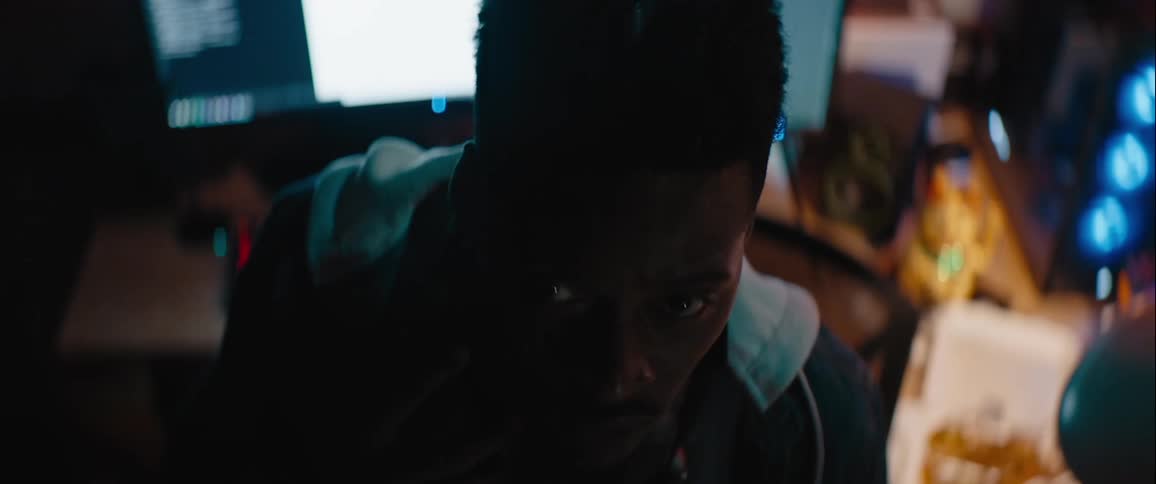 A man gets up from the desk and looks behind him